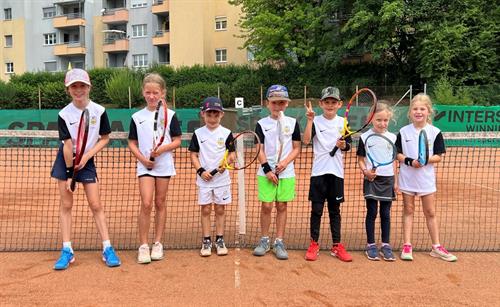 Eine Gruppe von Kindern hält Tennisschläger in der Hand